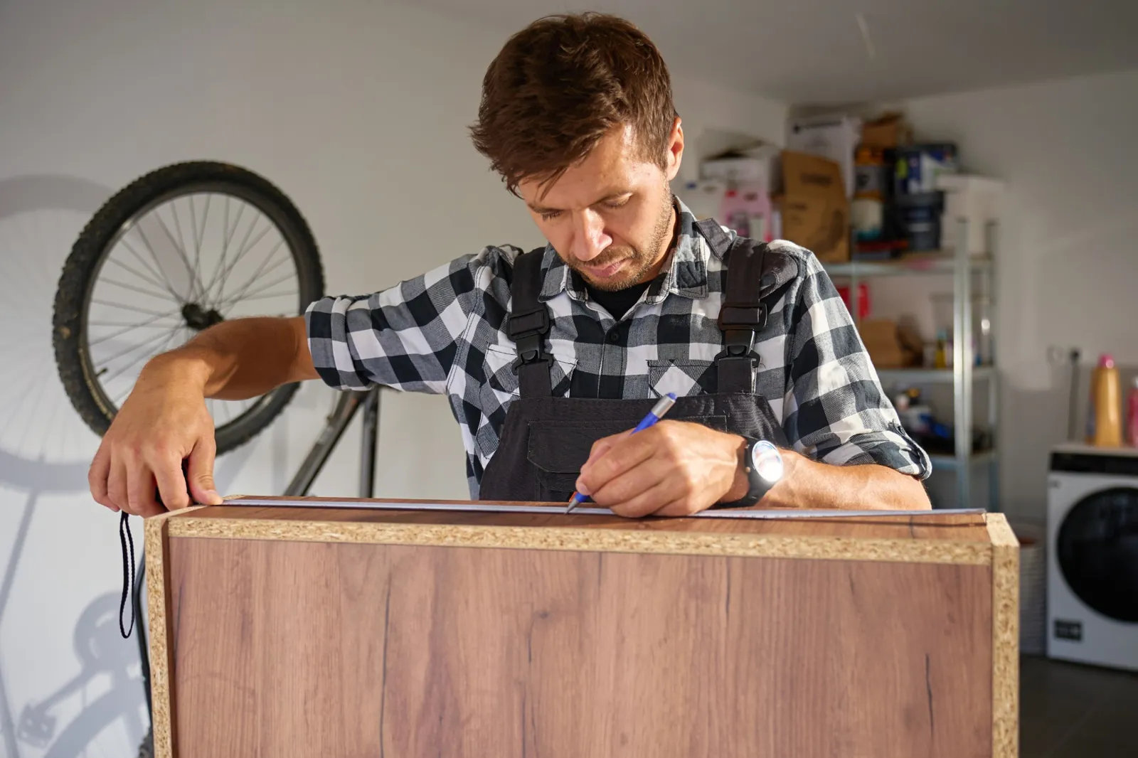 Tischler misst Holzplatten in der Werkstatt